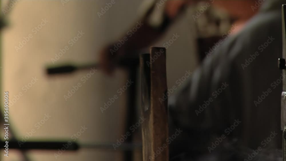 Glass Blower shaping a Bubble of Melted Glass on a Rod by Hand in the Manufacturing Process at a Glass Factory. Close Up. Glass Blower shaping a Bubble of Melted Glass on a Rod by Hand in the Manufacturing Process at a Glass Factory. Close Up.