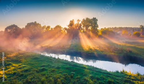 Awesome summer sunrise on the foggy river. Incredible morning scene with first sunlight, Ternopil region, Ukraine, Europe. Beauty of countryside concept background.
