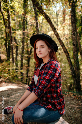 traveler hipster woman standing alone in autumn woods .