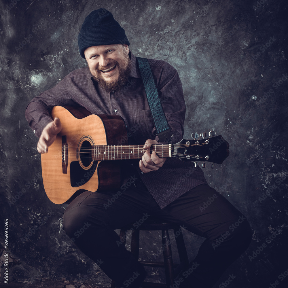Obraz premium Mature musician plays acoustic guitar emotional studio portrait.