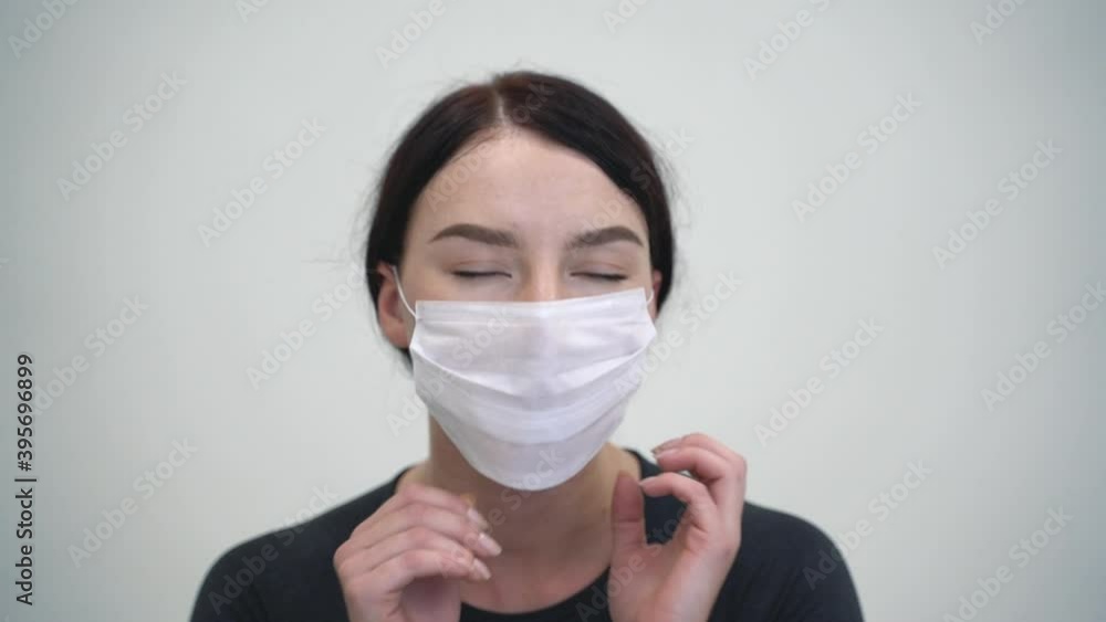 Portrait of woman putting on medical face mask before practicing yoga and workout at home Portrait of woman putting on medical face mask before practicing yoga and workout at home