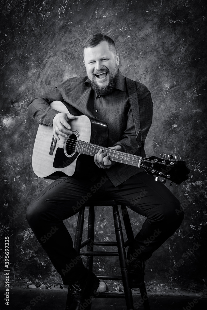 Obraz premium Mature musician plays acoustic guitar emotional studio portrait.