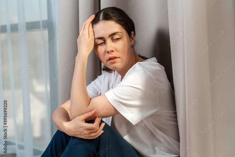 Portrait of frustrated woman holding her head with her hand. The concept of domestic violence Portrait of frustrated woman holding her head with her hand. The concept of domestic violence