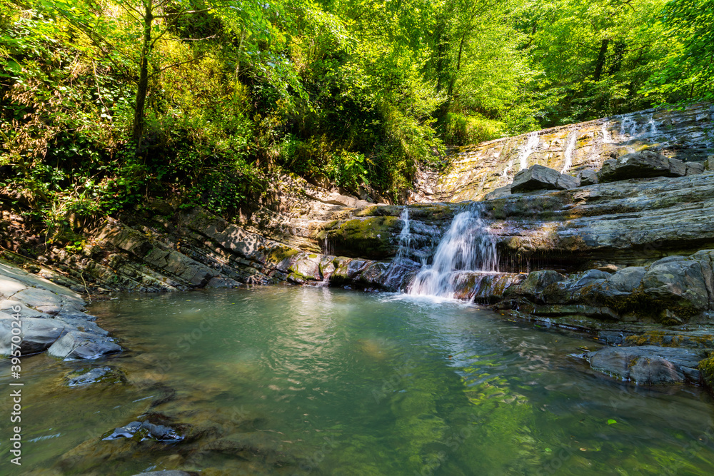 Obraz premium Long exposure photo of a small waterfall or water stream with a big rocks