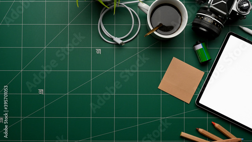 Workspace with tablet, camera, stationery, coffee cup and copy space on cutting board