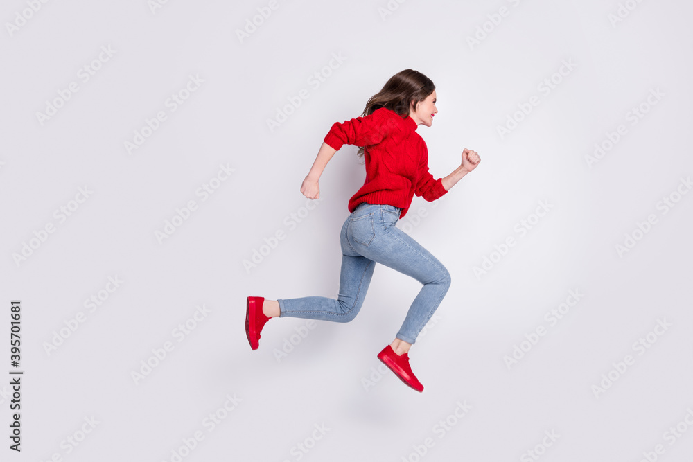 Full length body size photo of jumping high running fast on sale girl in jeans red sweater isolated on grey pastel color background