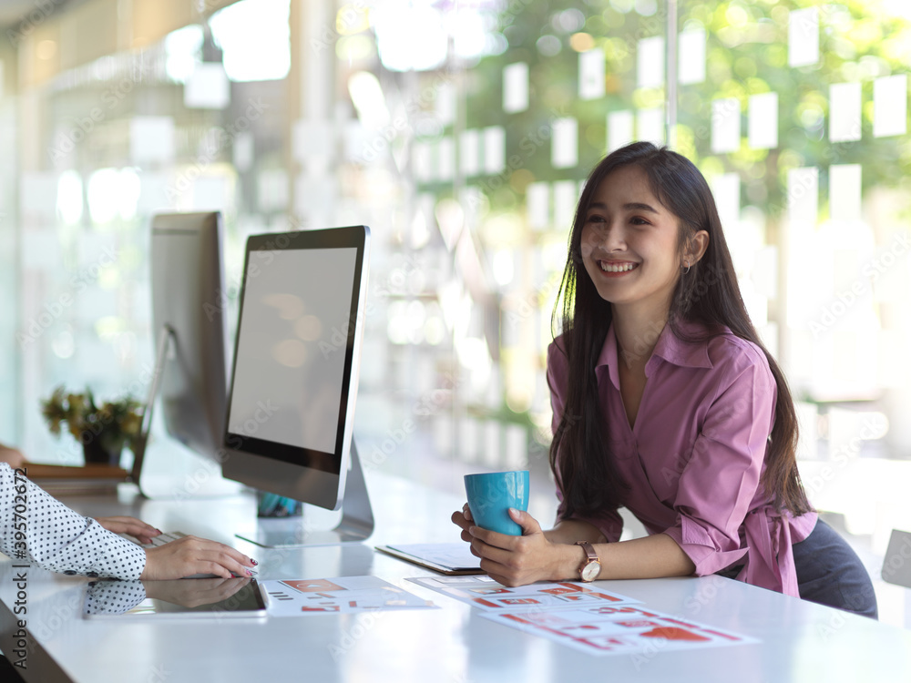 Fototapeta premium Female office worker taking coffee break while meeting on group project