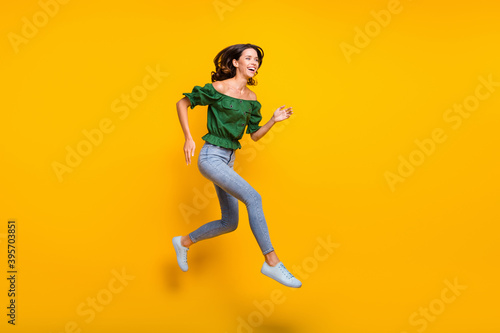 Full size profile side photo of funky woman run jump up copyspace discount shopping isolated on yellow color background
