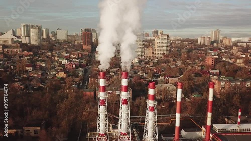 from the boiler room tube goes white steam, smoke into the sky. heating in winter. industrial zone in the city. Cityscape. photo