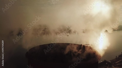 close up. from the boiler room tube goes white steam, smoke into the sky. heating in winter. industrial zone. photo