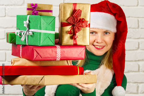 wwoman in red hat holding many christmas gifts. woman holding a lot of boxes with gifts photo