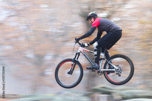 Man cycling fast with mountainbike in a forest in fall