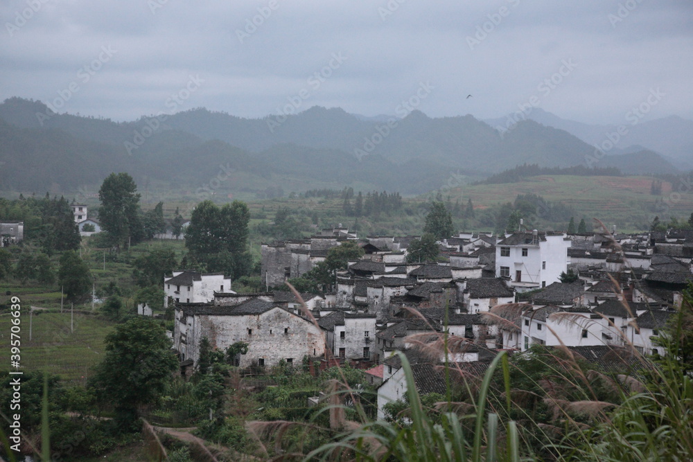View of Ancient village and its Chinese Huizhou Architecture style residential houses with mountains and forest in Wuyuan county, Jiangxi province, China.