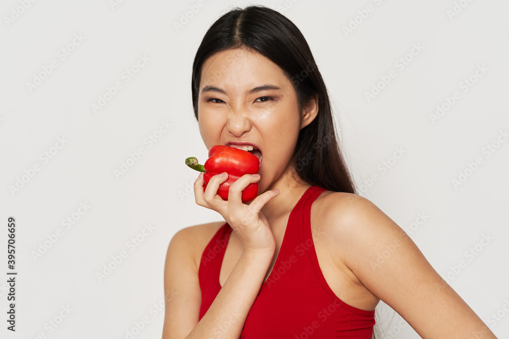 Woman eating red pepper healthy food vegetarian slim figure Woman eating red pepper healthy food vegetarian slim figure