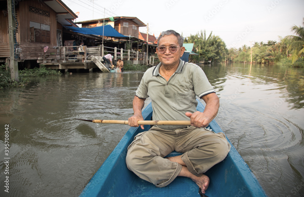 senior old asian man roll boat in the river in long life active senior old asian man roll boat in the river in long life active