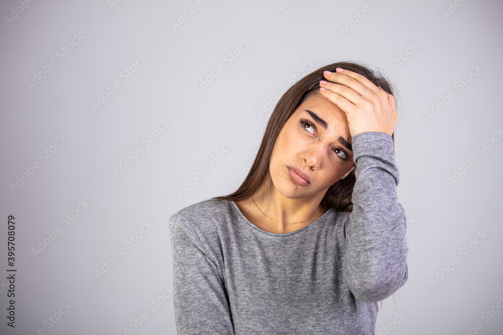 Woman grabbing her head and rubbing temples because of headache. Studio shot, white background. Human emotions, facial expression concept. Close-up of young pretty woman with painful face Woman grabbing her head and rubbing temples because of headache. Studio shot, white background. Human emotions, facial expression concept. Close-up of young pretty woman with painful face