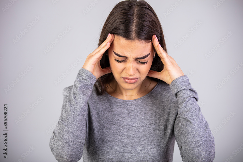 Woman grabbing her head and rubbing temples because of headache. Studio shot, white background. Human emotions, facial expression concept. Close-up of young pretty woman with painful face Woman grabbing her head and rubbing temples because of headache. Studio shot, white background. Human emotions, facial expression concept. Close-up of young pretty woman with painful face
