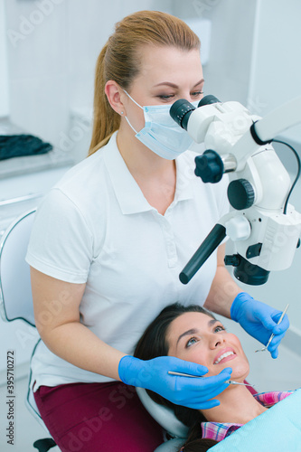 Cheerful patient undergoing teeth treatment with professional dentist