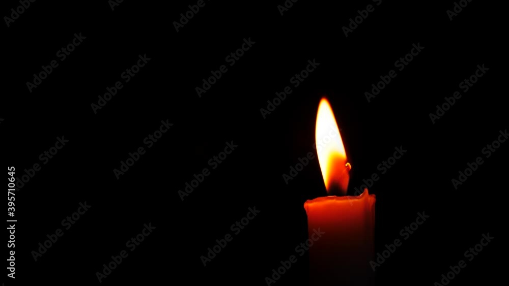 Close-up burning single candle flame isolated on black background, 4K video Close-up burning single candle flame isolated on black background, 4K video