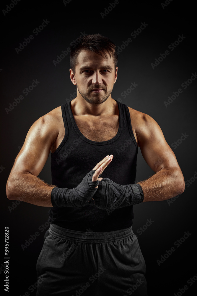 Muscular sporty handsome man in boxing bandage on black backgrround Muscular sporty handsome man in boxing bandage on black backgrround