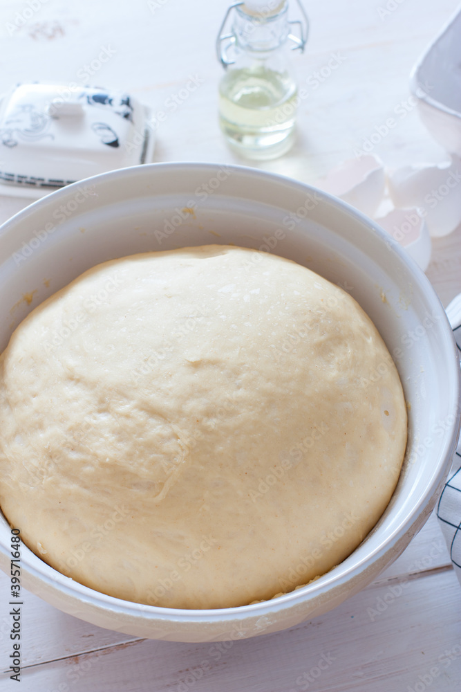 Freshly cooked yeast dough in ceramic bowl on white wooden table, selective focus Freshly cooked yeast dough in ceramic bowl on white wooden table, selective focus