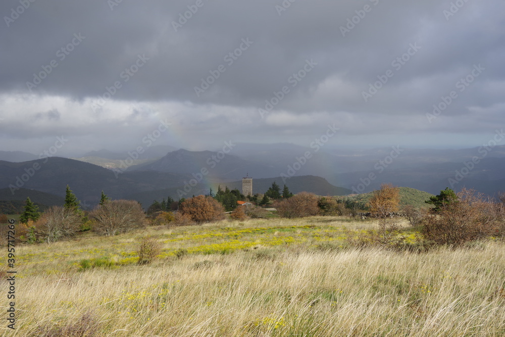 Village de Prats de Sournia dans les Pyrénées Orientales du fenouillèdes avec son clocher et arc en ciel sous l'orage de pluie