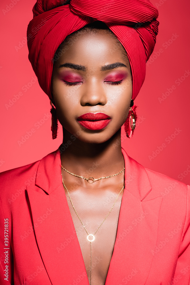 african american woman in stylish outfit and turban with closed eyes isolated on red african american woman in stylish outfit and turban with closed eyes isolated on red