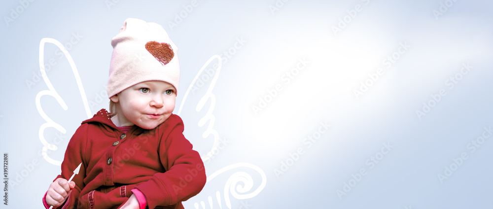 Little Caucasian girl with wings behind her back, smiling and looking cheerfully. Concept child bought it for Valentine's Day. Little Caucasian girl with wings behind her back, smiling and looking cheerfully. Concept child bought it for Valentine's Day.