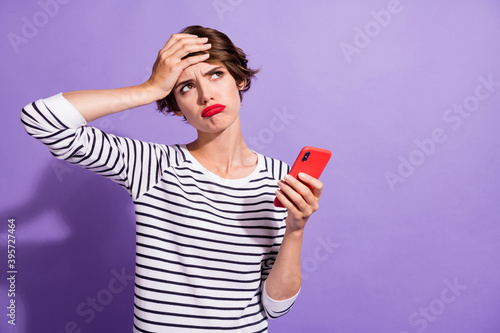 Obraz na plátně Photo of troubled upset girl hold cellphone palm brow look empty space wear stri