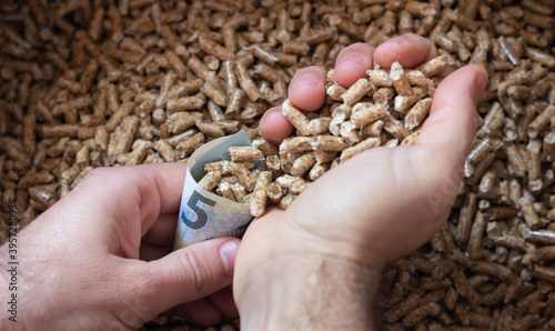 Hands filling bill cone with pellets biomass, save money