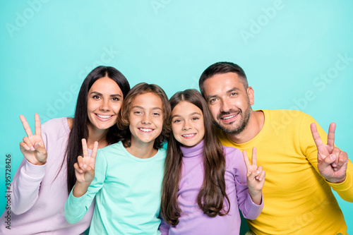 Photo portrait of big family showing v-signs isolated on vivid turquoise colored background