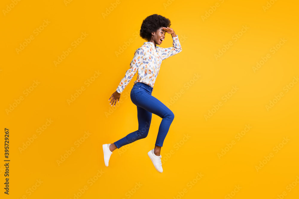 Full size profile side photo of brunette trendy girl wear blue pants white shirt jump run look copyspace isolated on yellow color background