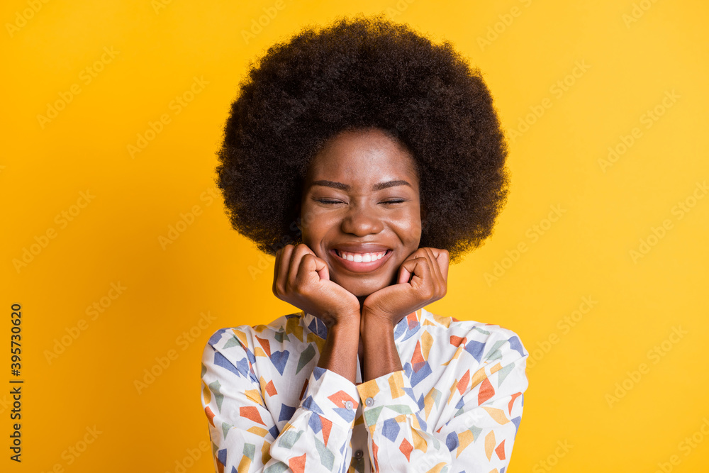 Photo of attractive lady hands under chin closed eyes toothy smile isolated on yellow color background Photo of attractive lady hands under chin closed eyes toothy smile isolated on yellow color background