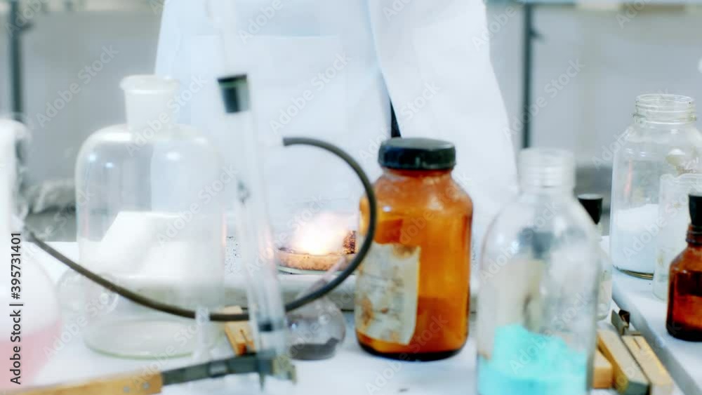 In the scientist laboratory closeup in front of the camera female make a experiment using some chemical substance and fire In the scientist laboratory closeup in front of the camera female make a experiment using some chemical substance and fire