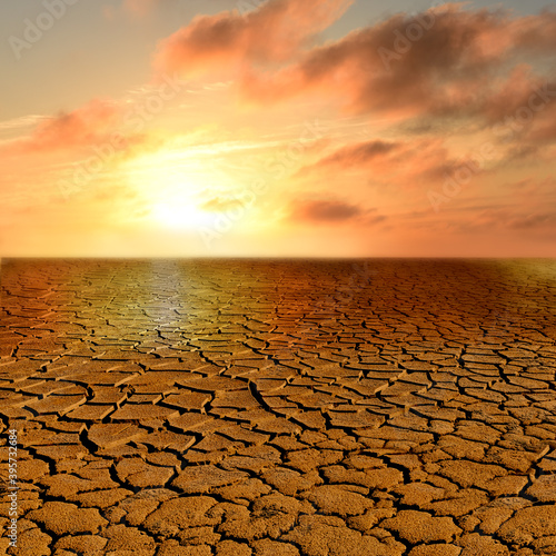Apocalyptic Landschatf. Cracked earth and red sunset. Super realistic photo.