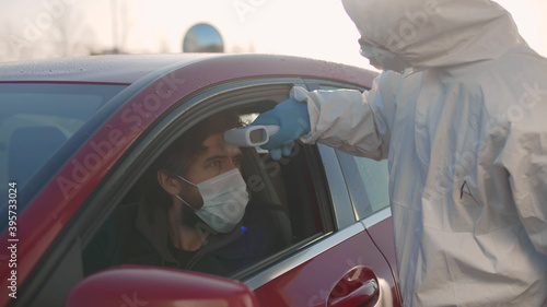 Doctor using infrared thermometer gun to check body temperature of driver © nimito