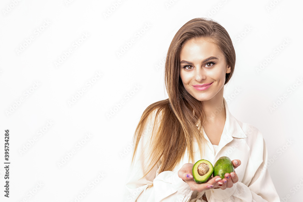 Beautiful young caucasian woman with halves of avocado on white background Beautiful young caucasian woman with halves of avocado on white background