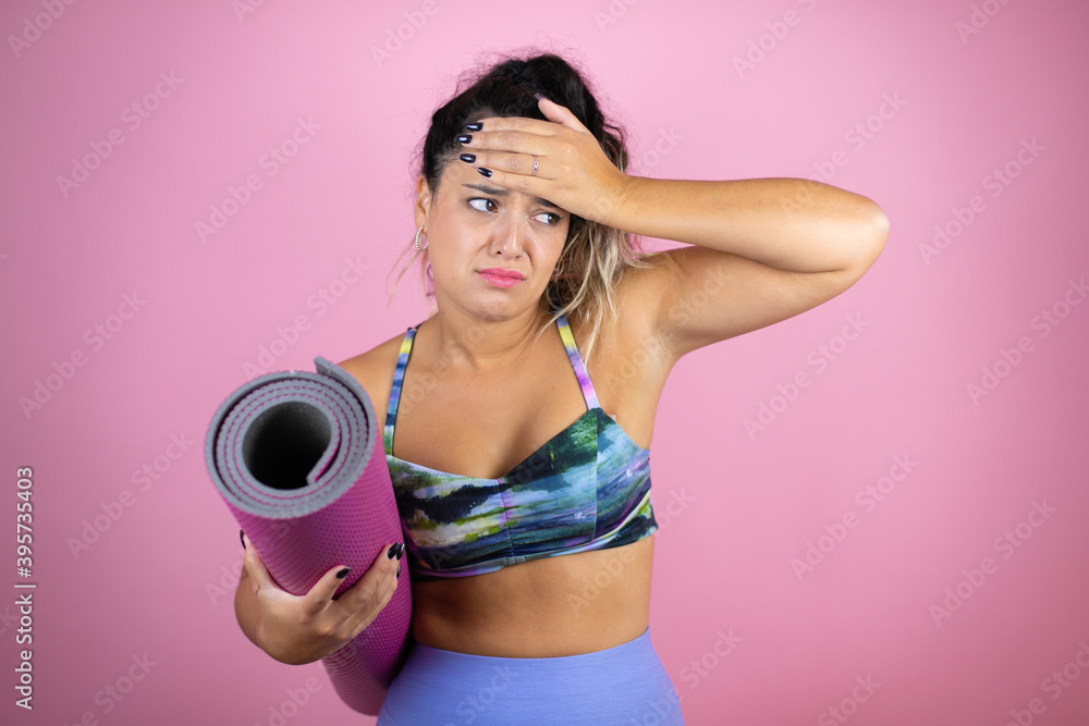 Young beautiful woman wearing sportswear and holding a splinter over isolated pink background Touching forehead for illness and fever, flu and cold, virus sick Young beautiful woman wearing sportswear and holding a splinter over isolated pink background Touching forehead for illness and fever, flu and cold, virus sick