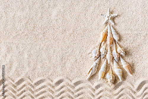 Fototapeta Naklejka Na Ścianę i Meble -  Sea shells and star fish Christmas tree on clear sand, top view