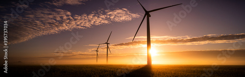 Billede på lærred Three commercial wind turbines in thick fog at sunrise in the English countrysid
