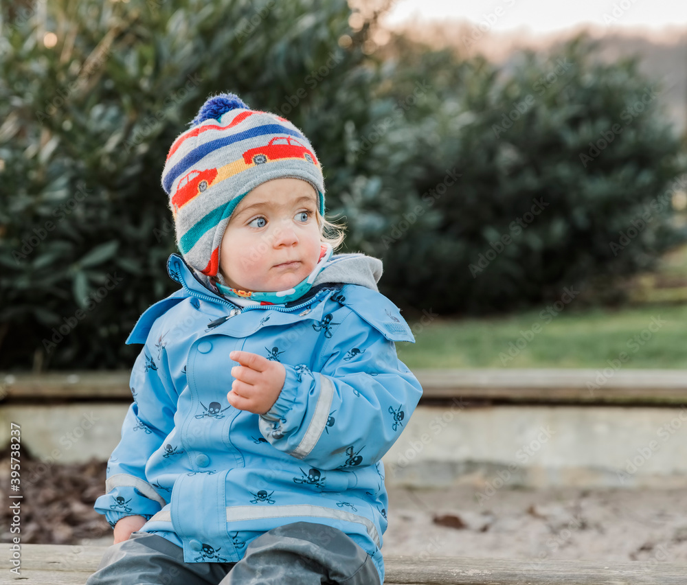 Toddler girl sitting on wooden bench Toddler girl sitting on wooden bench