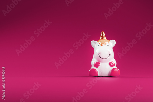 Unicorn figurine on a pink background. Free space. © Alexander