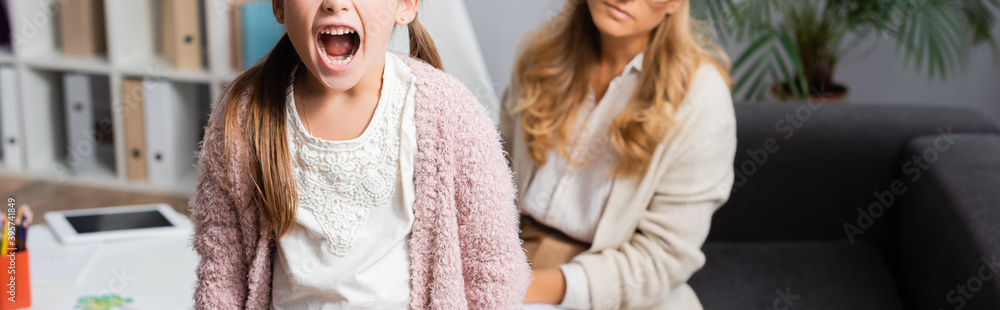 Naklejka premium cropped view of little girl screaming while visiting psychologist, banner