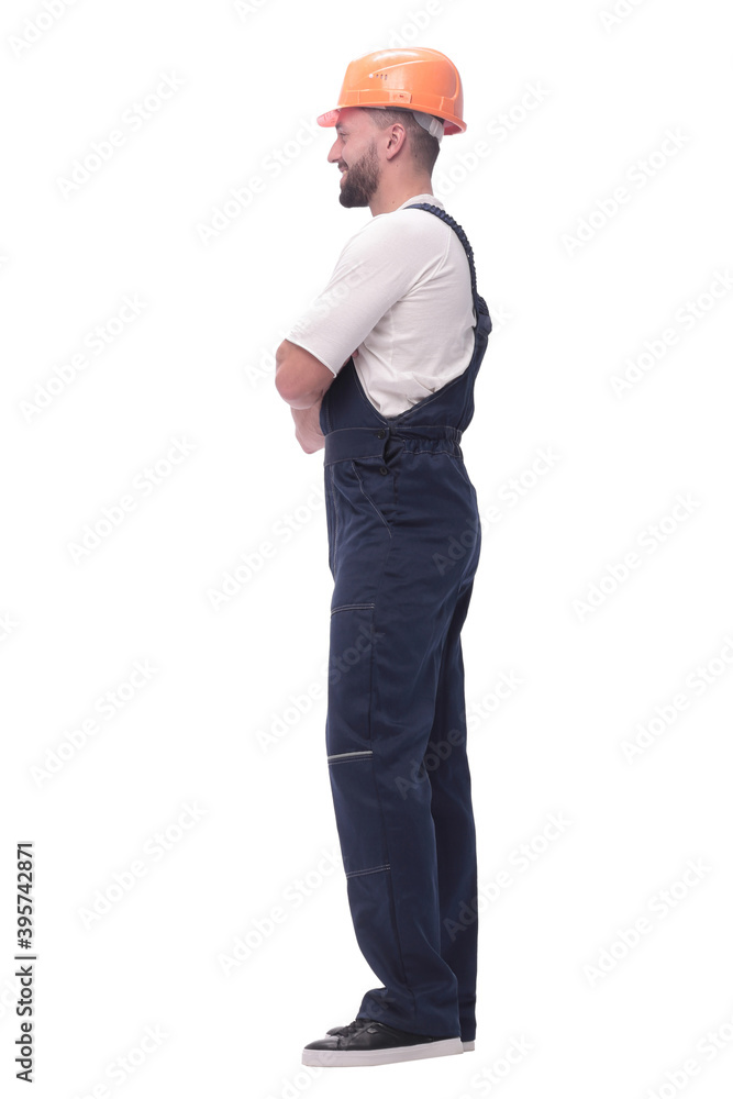 in full growth. smiling man in overalls and a safety helmet in full growth. smiling man in overalls and a safety helmet
