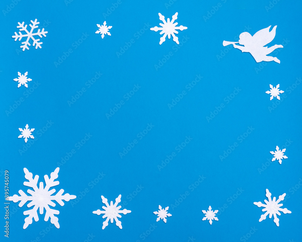 flat lay composition with white blank notepad, blue bell, white angel playing the trumpet and Christmas snowflakes flat lay composition with white blank notepad, blue bell, white angel playing the trumpet and Christmas snowflakes