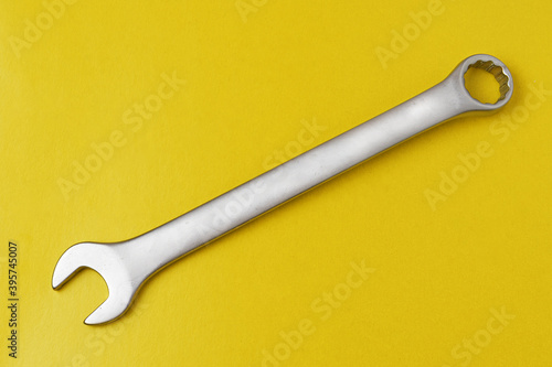 Open-end wrench on yellow background close-up