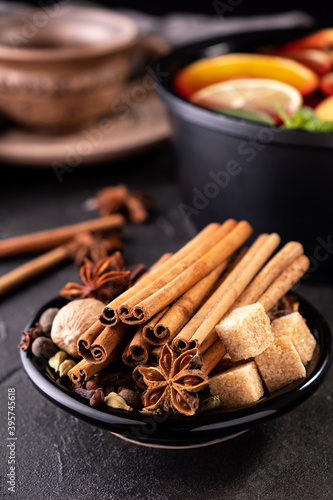 Collection of spices for mulled wine and pastry on black background