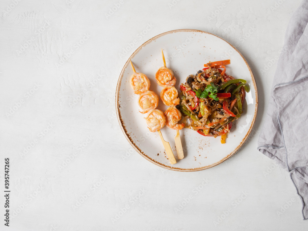 Prawn Skewer and vegetables stir fry on white plate. top view. Prawn Skewer and vegetables stir fry on white plate. top view.