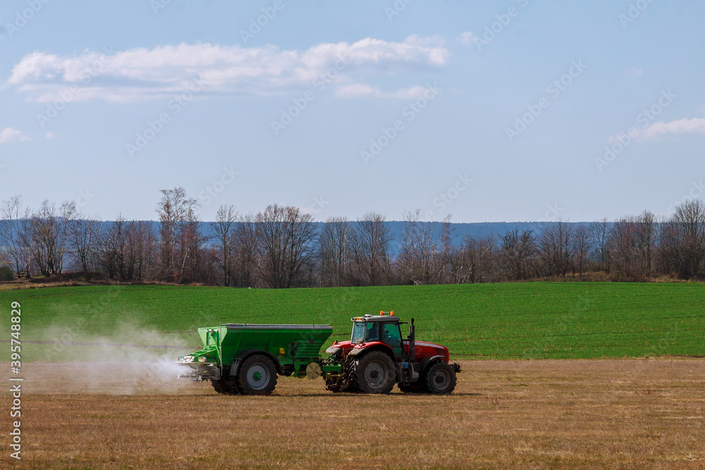 Tractor spreading fertilizer on grass field. Agricultural work. Tractor spreading fertilizer on grass field. Agricultural work.