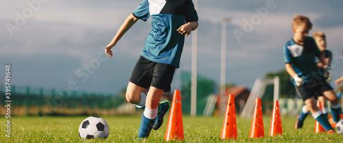 Soccer Training Drill For Kids. Young Football Players Practicing Soccer Skills. Children Running After Balls on Slalom Drill With Cones © matimix